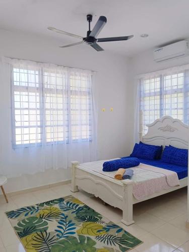 een slaapkamer met een bed en een plafondventilator bij Malin's Homestay Kota Bharu in Kota Bharu