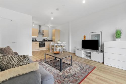 ein Wohnzimmer mit einem Sofa und einem Tisch in der Unterkunft Centrally Located Modern 2Bed 2Bath Apartment in London