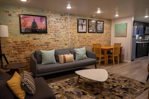 sala de estar con sofá y pared de ladrillo en Centrally Located DC Apt Bloomingdale en Washington