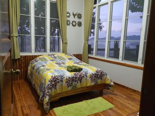 a small bed in a room with windows at One&only homestay in Khao Kho