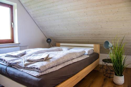 Cama en habitación con techo de madera en Gemütliche Galerie-Wohnung in Biberach, en Biberach an der Riß