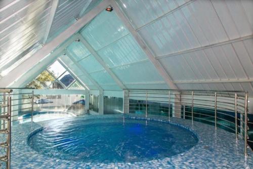 a large swimming pool in a building with a ceiling at Hotel Dan Inn Campos do Jordão in Campos do Jordão