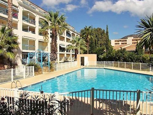 une grande piscine devant un immeuble dans l'établissement Appartement T2 cosy avec piscine, terrasse, parking sécurisé proche plage et commerces - Le Lavandou - FR-1-251-227, au Lavandou