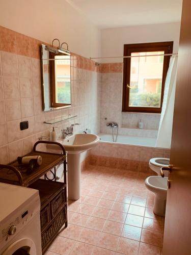 a bathroom with a sink and a tub and a toilet at LaMonica.House in Salò