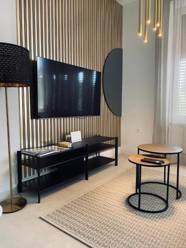 a living room with a flat screen tv on a wall at Rosetta Suite in Novi Vinodolski