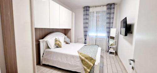 a small bedroom with a white bed and a window at Orchidea in Bologna
