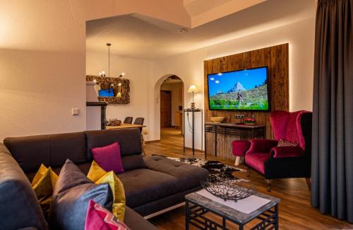 a living room with a couch and a tv at Ferienwohnungen Jägerheim & Jägerhaus in Ehrwald