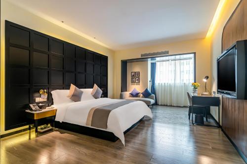 a bedroom with a large bed and a television at Empathy Hotel - Guangzhou East Railway Station Tianhe Sports Center in Guangzhou