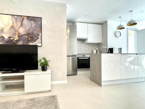 sala de estar con TV grande y cocina en WHITE DREAM Near the Sea 3bed by Solrentspain, en Mijas Costa