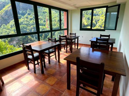 a restaurant with tables and chairs and large windows at MIRADOR DE LAS UBIÑAS in Ríospaso