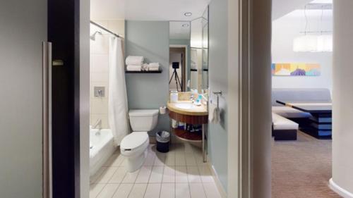 a bathroom with a toilet and a sink and a tub at Bay Lake Tower at Disney's Contemporary Resort in Orlando