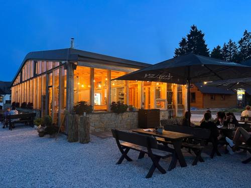 a group of people sitting at tables with umbrellas at Family 2 bedroom Ski&Bike Apartment with Terrase in Janske Lazne