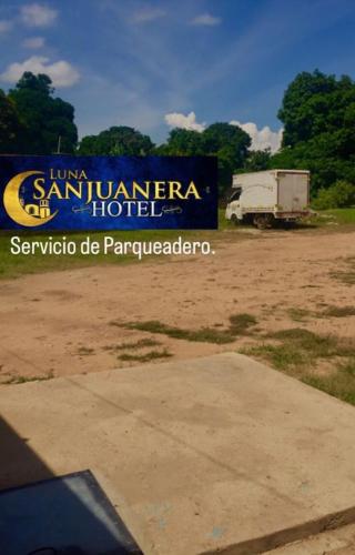 un camión estacionado en un campo junto a una señal en Hotel Luna Sanjuanera en San Juan del Cesar