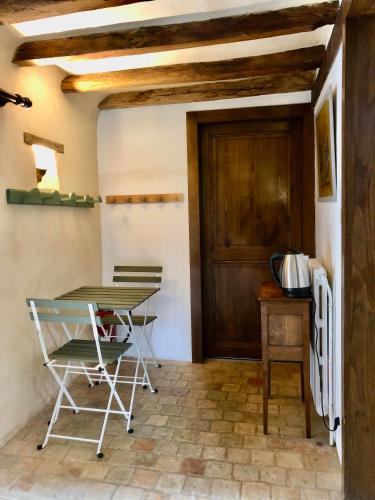a table and chairs in a room with a door at Chambre d'hôte à la Gilardière in Châtelain
