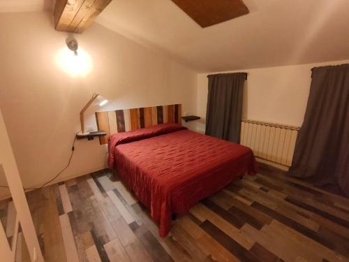 um quarto com uma cama com um edredão vermelho em casa vacanze Villanova - 4 posti letto em Villanova