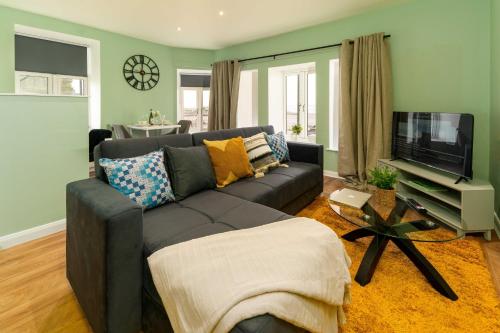 a living room with a couch and a flat screen tv at Clock Tower Retreat - Sea View Apartments in Morecambe in Morecambe