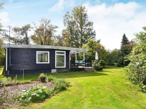 a black tiny house in a yard at 4 person holiday home in Holb k in Holbæk