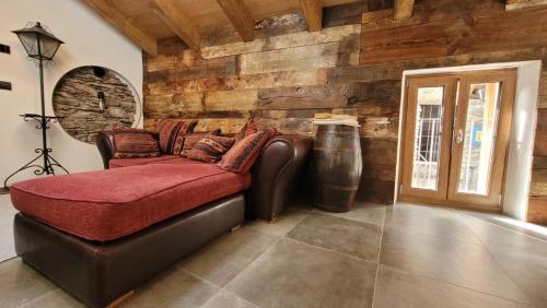 ein Wohnzimmer mit einem Ledersofa und einer Holzwand in der Unterkunft Widy's House in Bussoleno