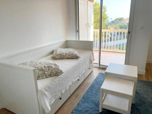 une chambre avec un lit, une table et une fenêtre dans l'établissement Appartement Vue Mer - Parking - Piscine - Plage, à Saint-Aygulf