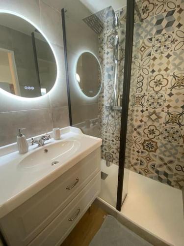 une salle de bain avec un lavabo et une douche dans l'établissement Appartement Vue Mer - Parking - Piscine - Plage, à Saint-Aygulf