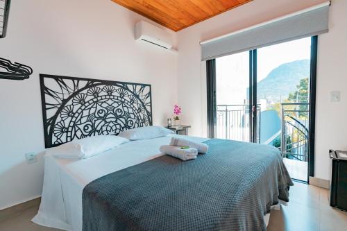 a bedroom with a large bed with a large window at Hospedaria da Barra BC in Balneário Camboriú