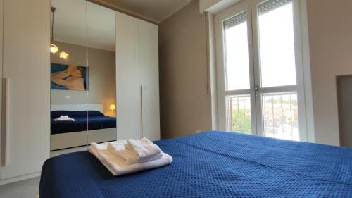 a bedroom with a blue bed with two towels on it at CASA MATISSE in Parma