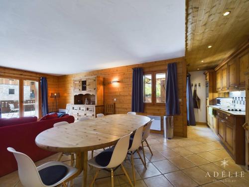 une cuisine et une salle à manger avec une table et des chaises en bois dans l'établissement Superbe 4 pièces à Montvalezan avec terrasse SE, proche pistes et commerces, parking inclus - FR-1-398-534, à La Rosière