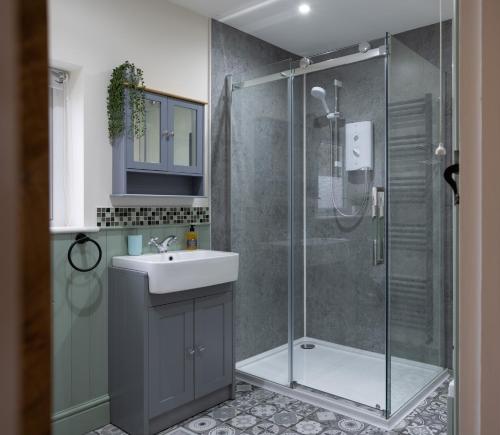 un bagno con lavandino e doccia in vetro di Family Country Cottage with Stunning Mountain View sleeps 12 a Myddfai