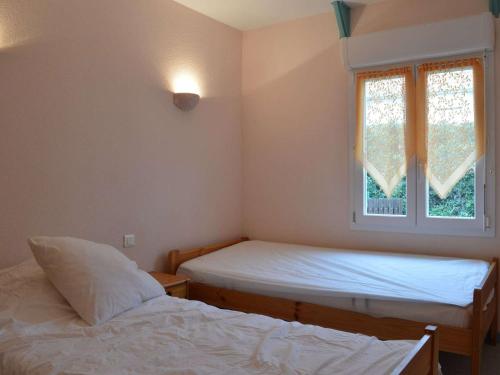 une chambre avec deux lits et une fenêtre dans l'établissement Maison proche plage et commerces, 3 pièces, climatisée, 6 couchages, animaux acceptés - FR-1-229D-57, à Fleury