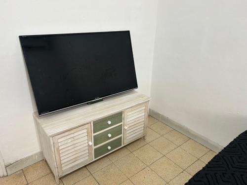 telewizor z płaskim ekranem siedzący na szafce w obiekcie LUXURY privet room near Tel Aviv w mieście Petach Tikwa