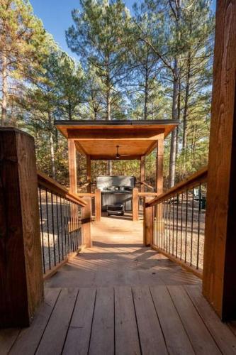 a screened in porch with a grill on a deck at The Blaylock Cabin, 2 King, Hot Tub, Pet Friendly! in Broken Bow