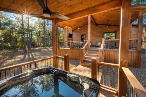 a porch of a log cabin with a swimming pool at The Blaylock Cabin, 2 King, Hot Tub, Pet Friendly! in Broken Bow