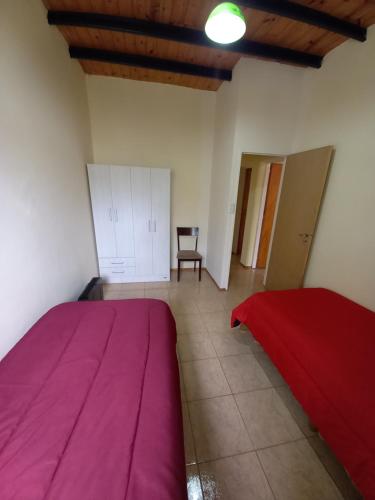 1 dormitorio con 1 cama de color púrpura y 1 silla en DEPARTAMENTOS CORDOBA 1590 en San Juan
