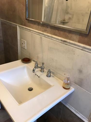 un lavandino bianco in un bagno con specchio di Little Castle a Villanova