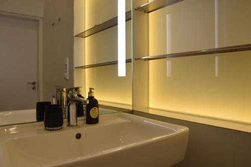 een witte wastafel in een badkamer met een spiegel bij Apartment DeLuxe in Praag