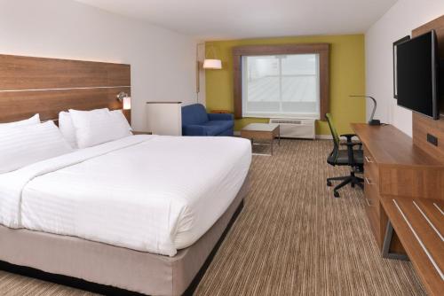 a hotel room with a large bed and a television at Holiday Inn Express & Suites - Ogallala by IHG in Ogallala