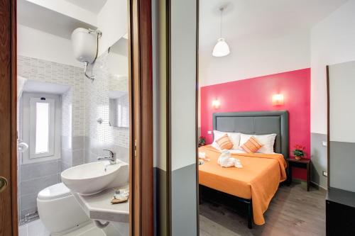 a bedroom with a bed and a bathroom with a sink at MF Hotel in Rome