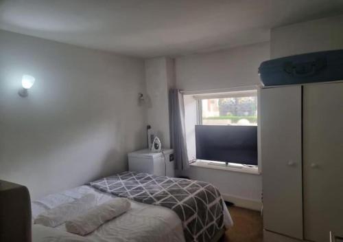 a bedroom with a bed and a large window at Your Riverside Home in Woolwich