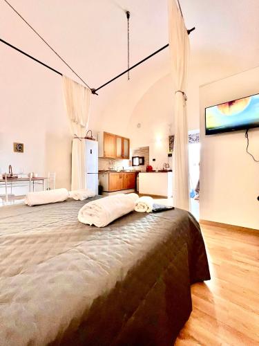 een groot bed in een kamer met een keuken bij Casa Vacanza L'Alchimista Mottola in Mottola