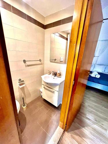 ein Badezimmer mit einem weißen Waschbecken und einem Spiegel in der Unterkunft Casa Vacanza L'Alchimista Mottola in Mottola
