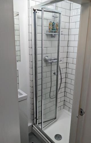 a shower with a glass door in a bathroom at Private room with terrace and free parking in Edinburgh