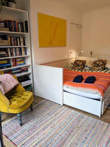 a bedroom with a large bed and a chair at Private room with terrace and free parking in Edinburgh