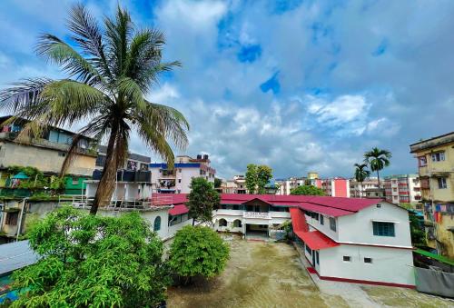 a city with a palm tree and buildings at Levi Home Guest House & Retreat Centre in Siliguri
