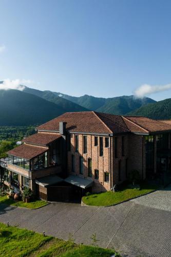 a large building with mountains in the background at Mtserlebi Resort in K'vishkhet'i