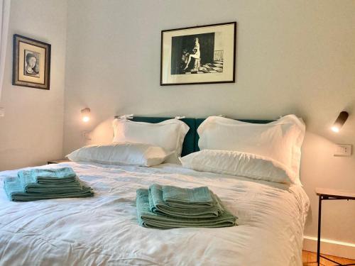 a white bed with towels on top of it at Maison Montello in Varese