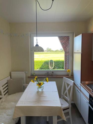 a kitchen with a table with flowers on it at Haus-Seeschwalbe-Wohnung-3 in Nieblum