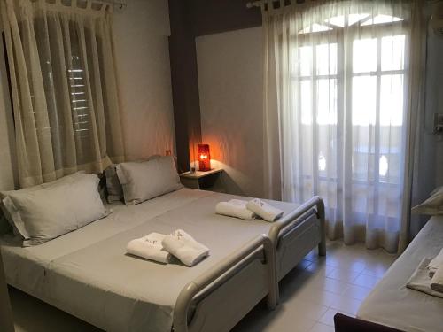 a bedroom with a large bed with towels on it at Villa Anna in Syvota