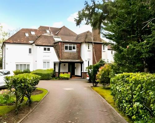 a large white house with a driveway at Exclusive Apartment in Greater London in Croxley Green