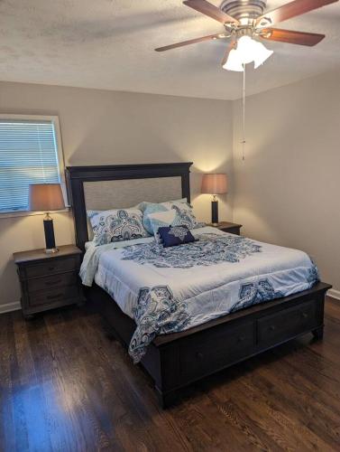 a bedroom with a bed with a ceiling fan and two lamps at Home away from home in Marietta