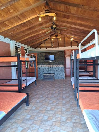 a room with several bunk beds and a tv at Finca Campestre Villa del Campo in Santa Rosa de Cabal